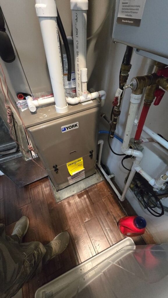 HVAC technician repairing a furnace in a Chicago home during an emergency 24/7 service call
