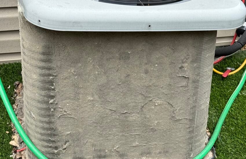 Dirty HVAC condenser unit with debris buildup causing reduced cooling performance