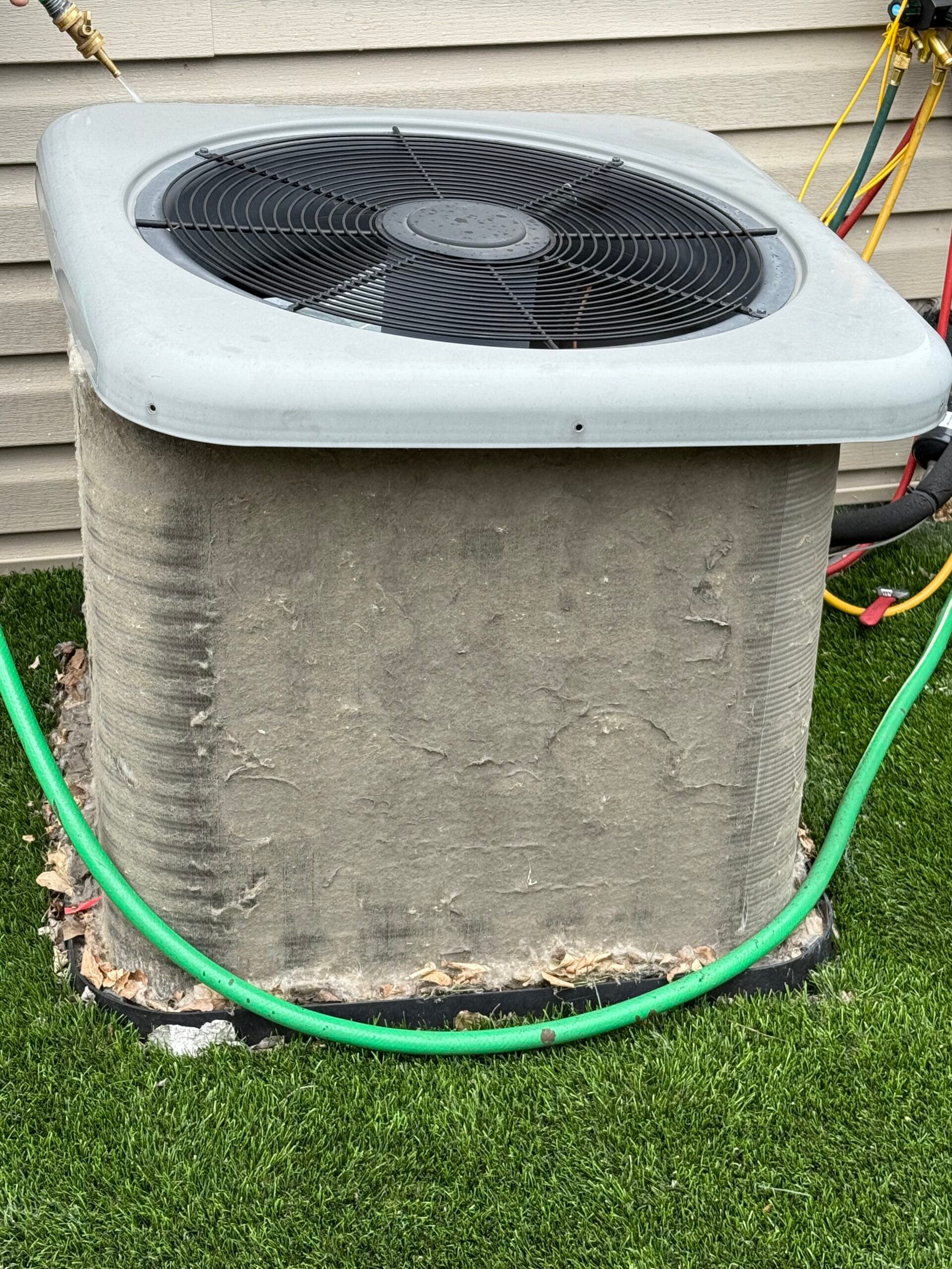 Dirty HVAC condenser unit with debris buildup causing reduced cooling performance